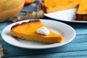 Tasty pumpkin pie on plate on a blue wooden table