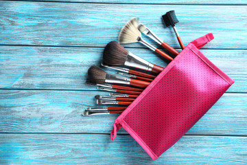Makeup brushes set on a blue wooden background