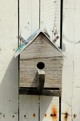 Handmade wood birdhouse on old, weathered gray background.