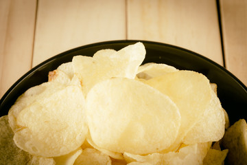 potato chips on wood - soft focus with vintage film filter