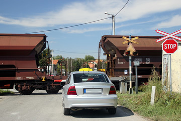 Car in front of the barrier and freight train