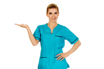 Smiling woman doctor or nurse pointing something