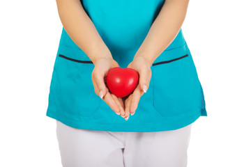 Nurse or female doctor holding red heart.