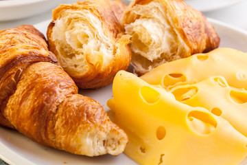 Croissants with cheese, fruits and coffee