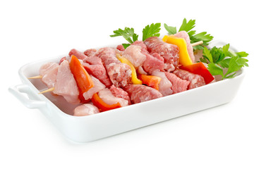 raw meat skewers in a porcelain tray