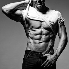 Fototapeta na wymiar Muscular man showing his muscular stomach.