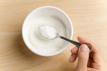 The spoon of sugar in the bowl,food ingredient for cooking sweet or dessert