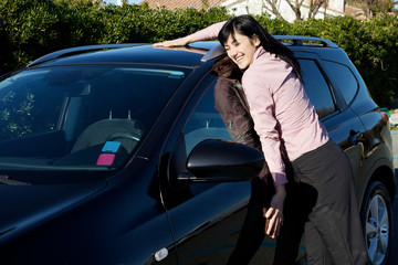 smiling woman hugging her new car