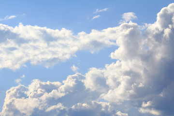 In the blue sky floating Cumulus clouds