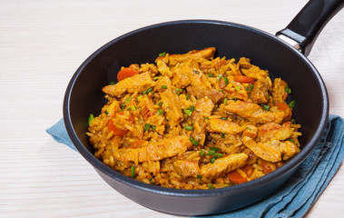 meat with rice and vegetables in a frying pan