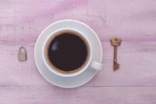 Closeup picture of cup of coffee with lock and key as symbol