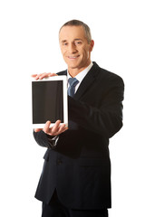 Happy businessman holding digital tablet