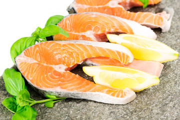 Salmon on stone with basil and lemon isolated on white