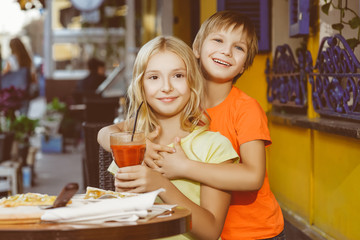 Happy or satisfied boy width girl eating pizza and drinking