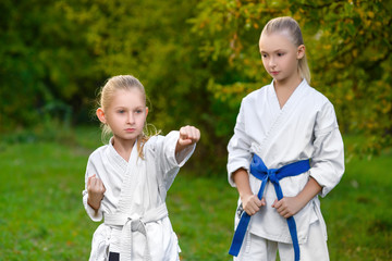 girls in white kimono during training karate exercises at summer
