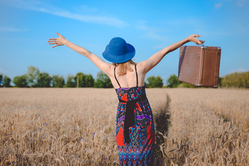 Carefree female in sundress and bowler hat holding retro