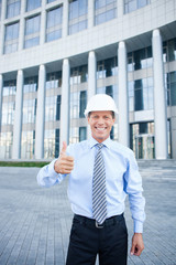 Cheerful senior engineer is gesturing with positive emotions
