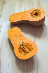 Butternut squash cut in half on a wooden surface