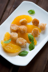 Glass plate with roasted sea scallops and orange fillet