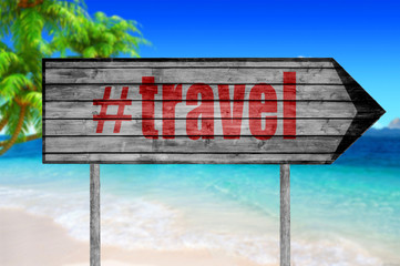Red The word with hashtag TRAVEL wooden sign with on a beach bac