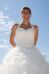 Fototapeta na wymiar A married woman bride in her wedding dress in sunshine on a beautiful tropical beach