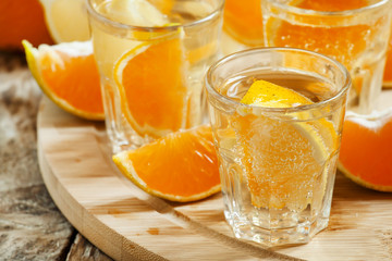Tangerine and lemon drink soda on a wooden table, selective focu