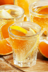 Tangerine and lemon drink soda on a wooden table, selective focu