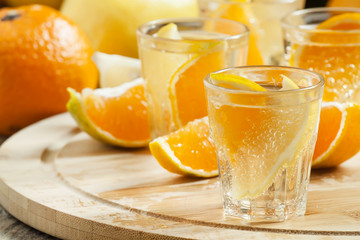 Tangerine and lemon drink soda on a wooden table, selective focu