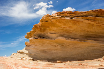 Sandstone rock against a blue, cloudy, sky