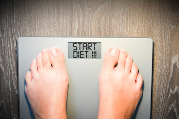 Start diet concept with person on a scale measuring weight