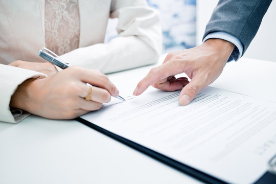 Female hand signing contract.