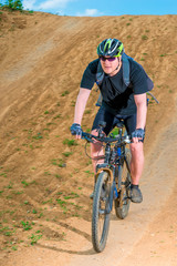 athlete wearing a helmet on a clay road cycling