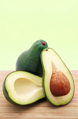 Whole and Sliced Avocados on a Wooden Table