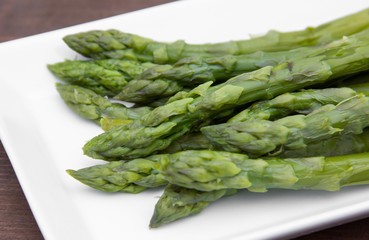 Asparagus on the tray on wooden table close