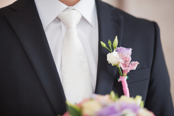 Boutonniere on trendy groom at wedding
