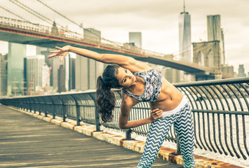 Obraz na płótnie Canvas Beautiful girl making stretching before intense running in New york city