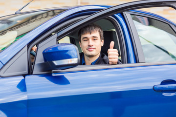 Handsome young man sitting in his car