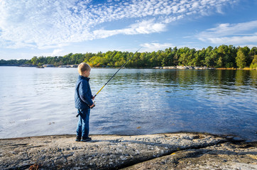 Small boy fishing in the sea
