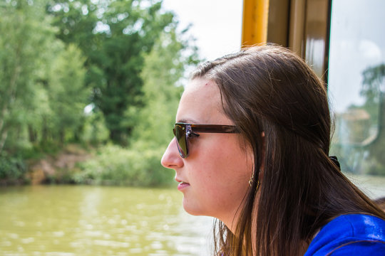 Young beautiful woman looking through window with sunglasses