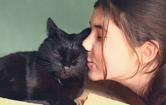 teen pretty girl kiss black cat close up portrait