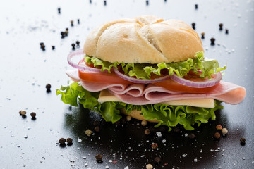 ham sandwich on black table