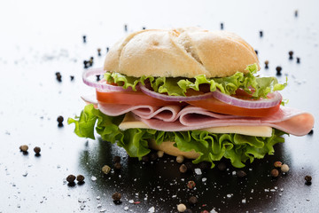ham sandwich on black table