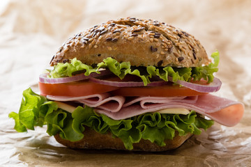 brown bun ham sandwich on paper
