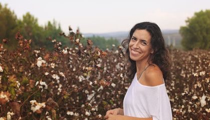 Portrait of beautiful 35 years old woman standing in cotton fiel
