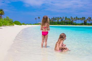 Fototapeta na wymiar Adorable little girls having fun during beach vacation