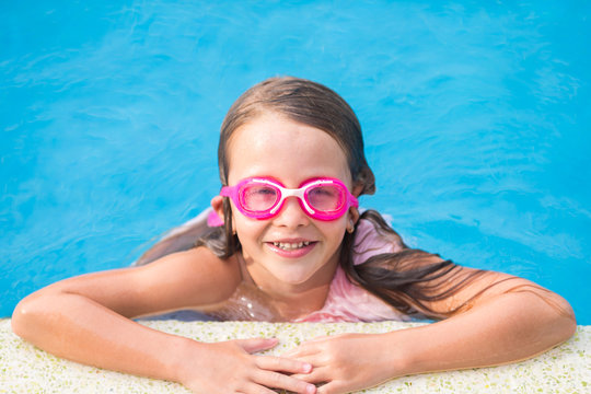 Adorable little girl in outdoor swimming pool