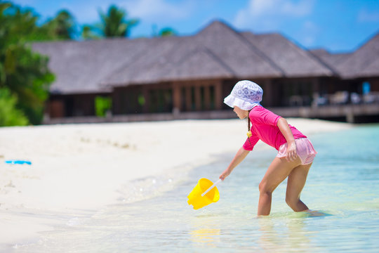 Adorable girl playing with beach toys during tropical vacation