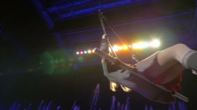 Girl swinging on the trapeze during performance