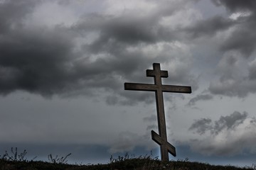 Деревянный крест на фоне грозовых облаков