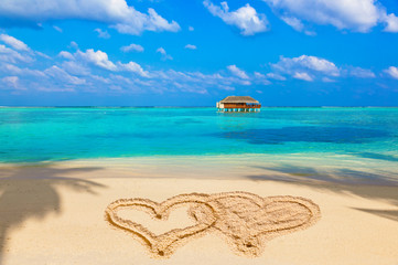 Drawing connected hearts on beach
